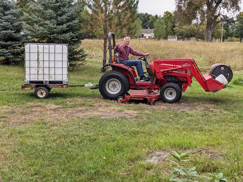 Dad on tractor with watering trailer