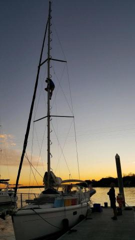 Aaron climbing the mast with a beautiful sunset